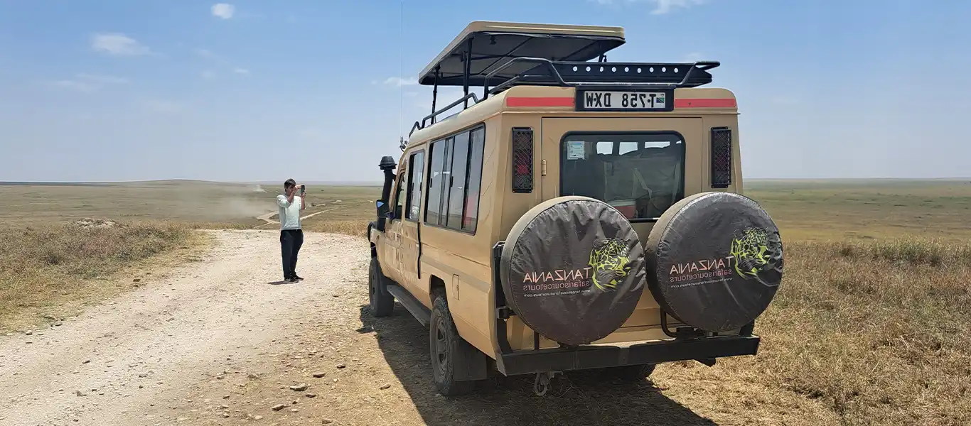 Luxury safari jeep with giraffe in Tanzania
